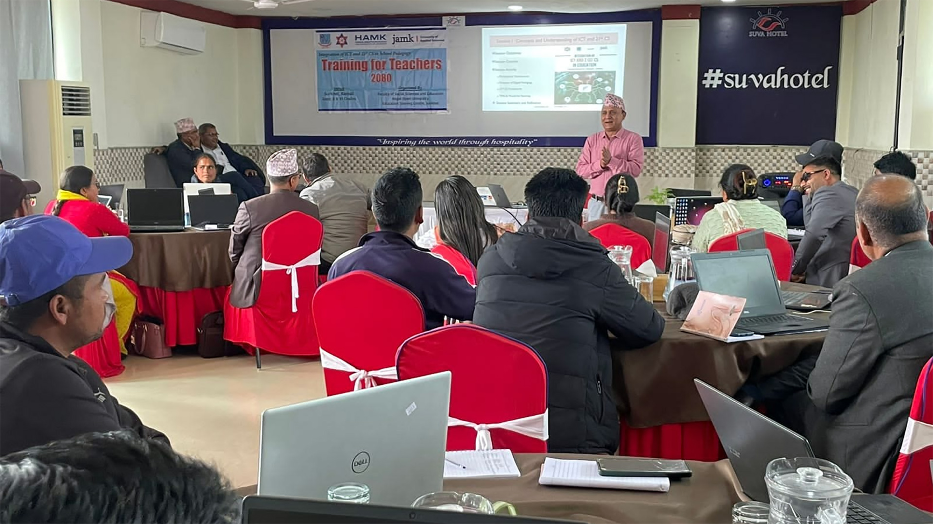 Dr Jiban Khadka presenting in a workshop. Over 20 people sitting by tables in a conference room.