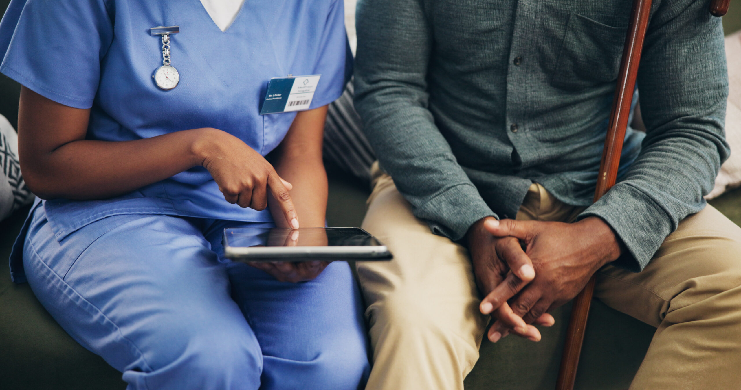 Woman, nurse and hands with tablet for elderly care, prescription or medical history at retirement home. Closeup, healthcare employee or caregiver with senior patient on technology for health tips